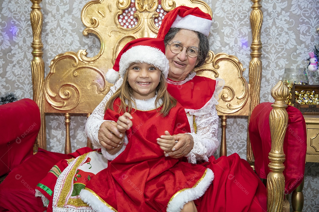 Vó tirando fotografia com sua neta celebrando natal ceia