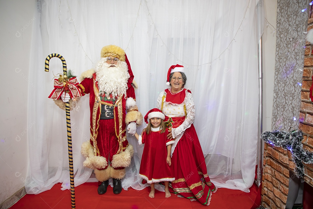 Vó tirando fotografia com sua neta e Papai Noel celebrando natal ceia