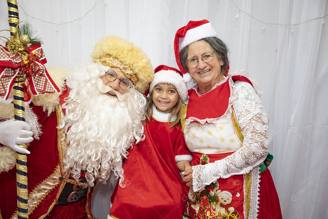 Vó tirando fotografia com sua neta e Papai Noel celebrando natal ceia