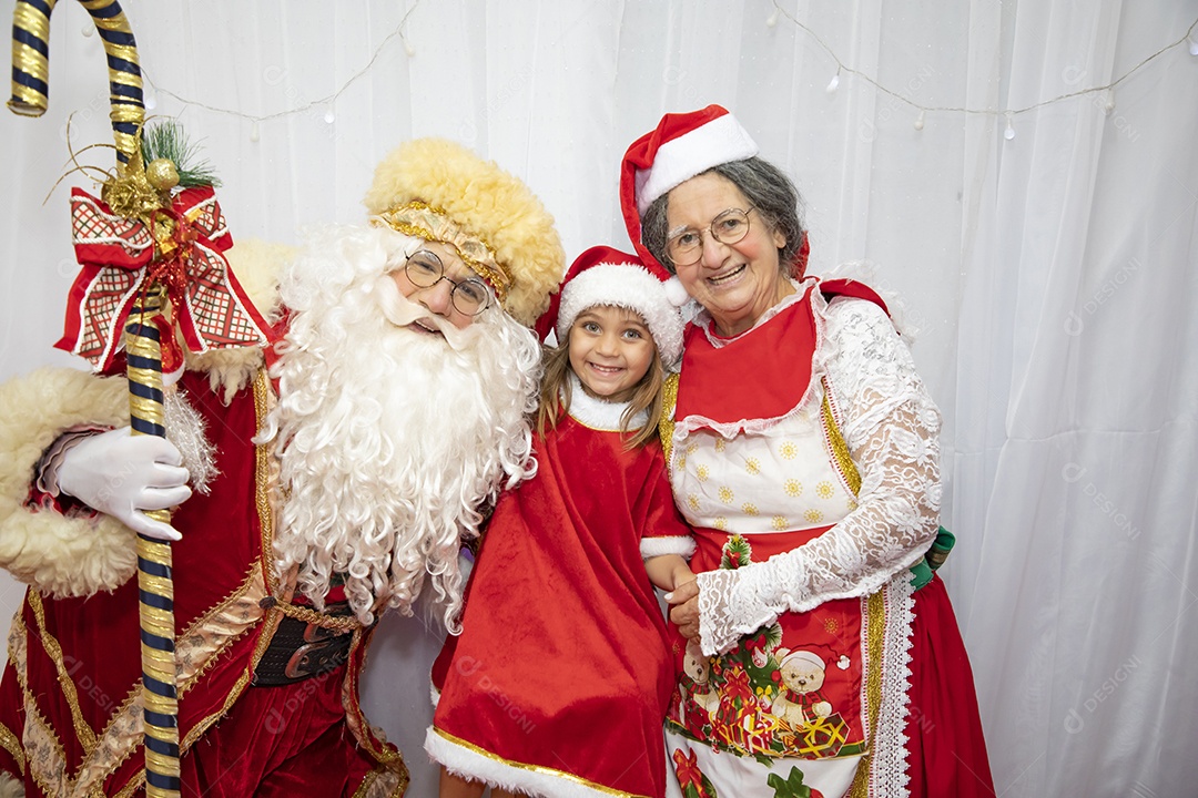 Vó tirando fotografia com sua neta e Papai Noel celebrando natal ceia