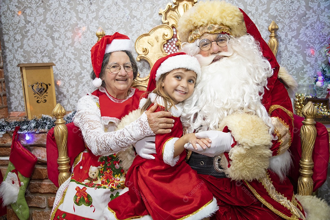 Vó tirando fotografia com sua neta e Papai Noel celebrando natal ceia