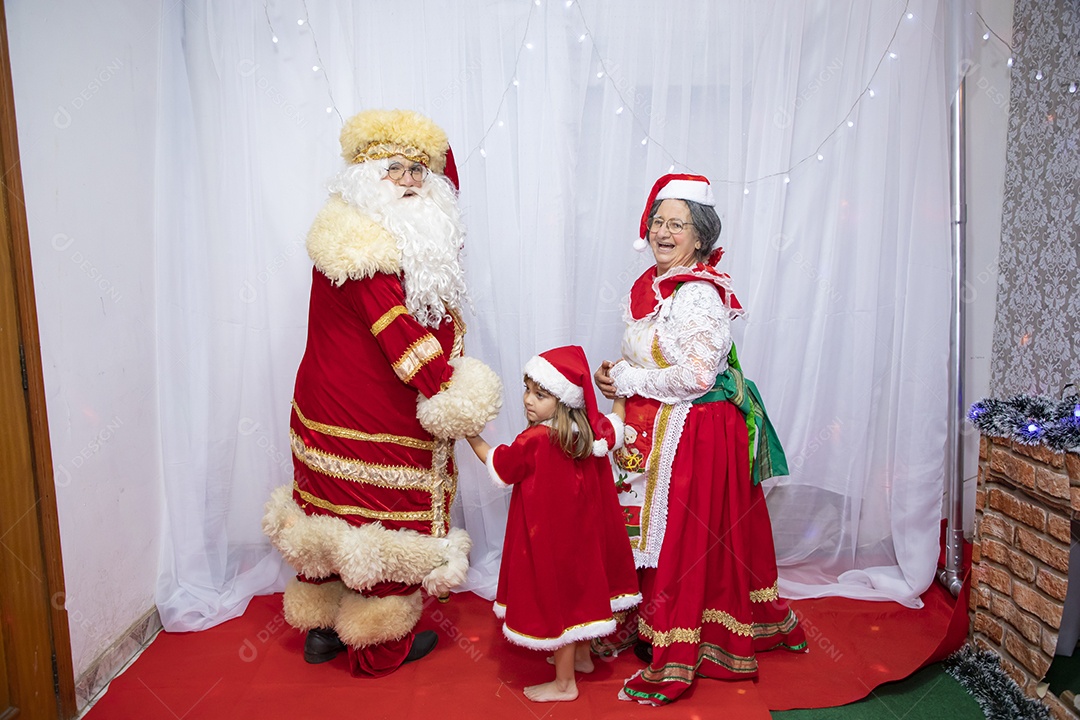 Vó tirando fotografia com sua neta e Papai Noel celebrando natal ceia