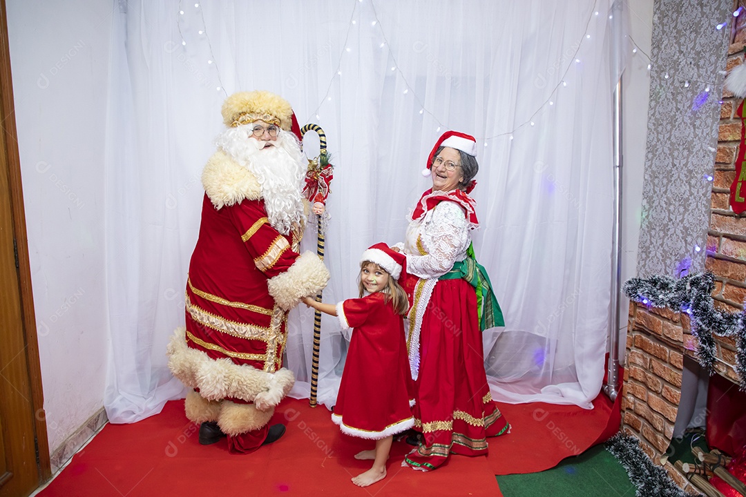 Vó tirando fotografia com sua neta e Papai Noel celebrando natal ceia
