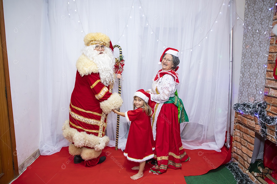 Vó tirando fotografia com sua neta e Papai Noel celebrando natal ceia