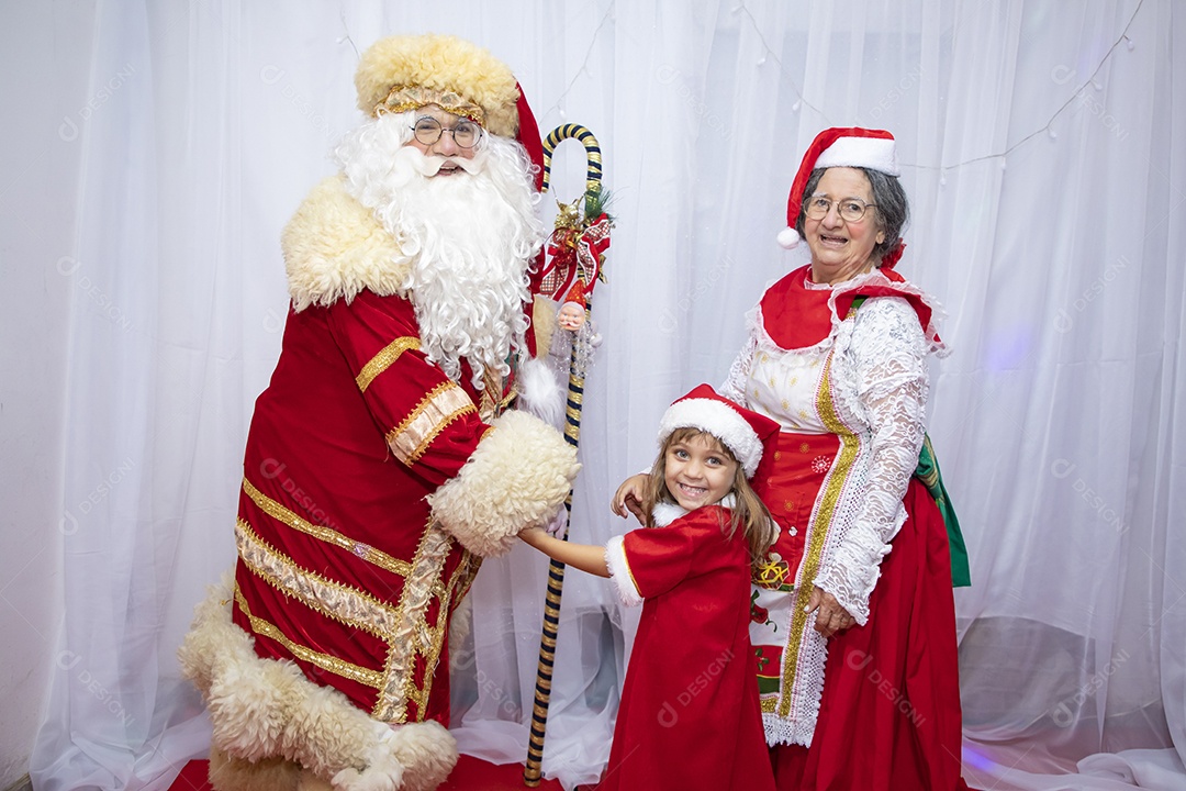 Vó tirando fotografia com sua neta e Papai Noel celebrando natal ceia