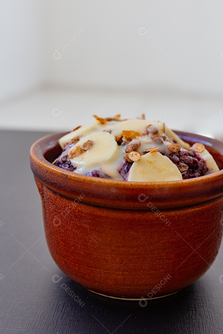 Tigela de barro açaí com coberturas granola frutas Banana