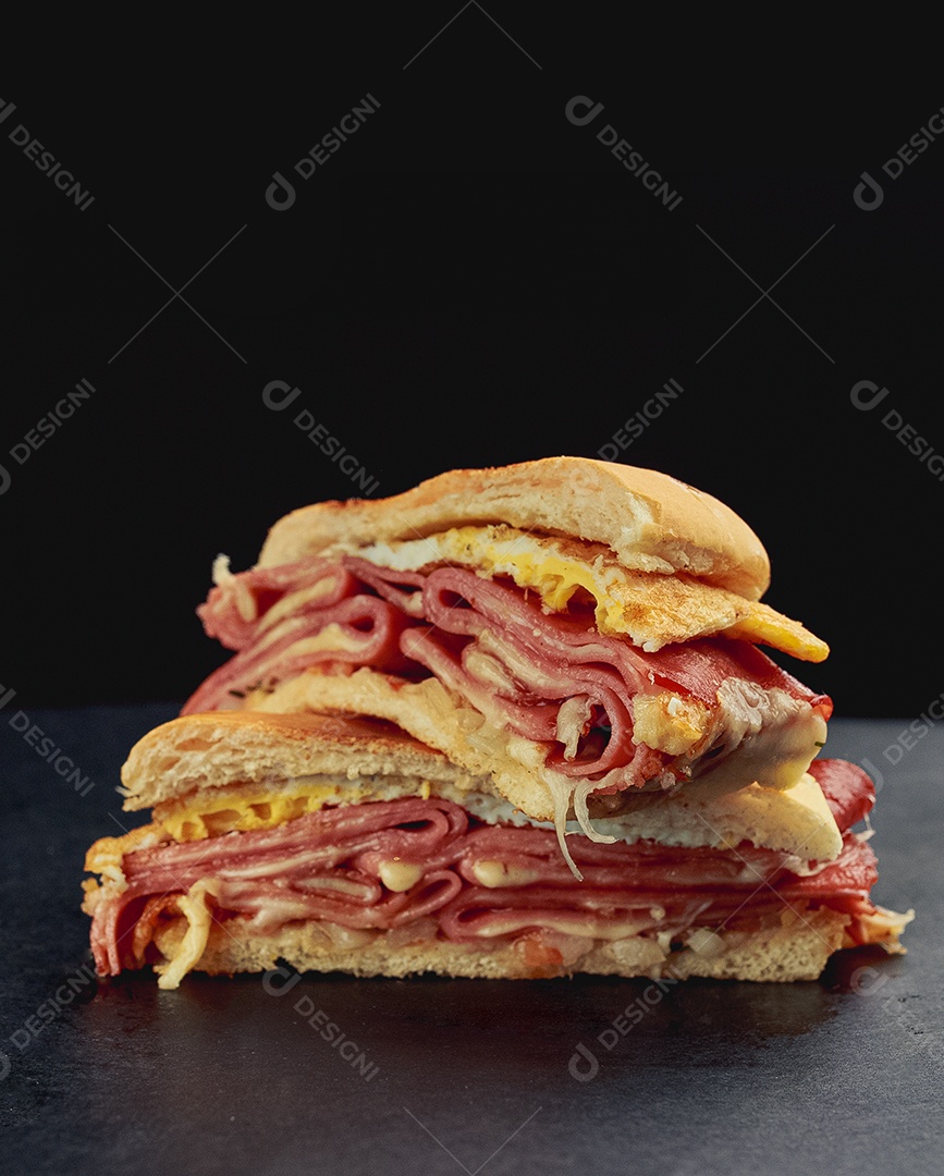 Misto cortado ao meio pão e presunto bacon e queijo