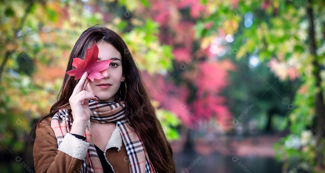 Moça bonita em uma paisagem de outono com uma folha