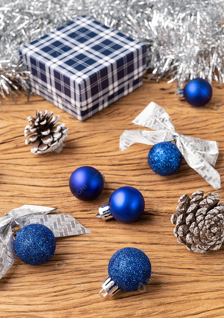Caixa de presente, bolas de natal e arco sobre a mesa de madeira.