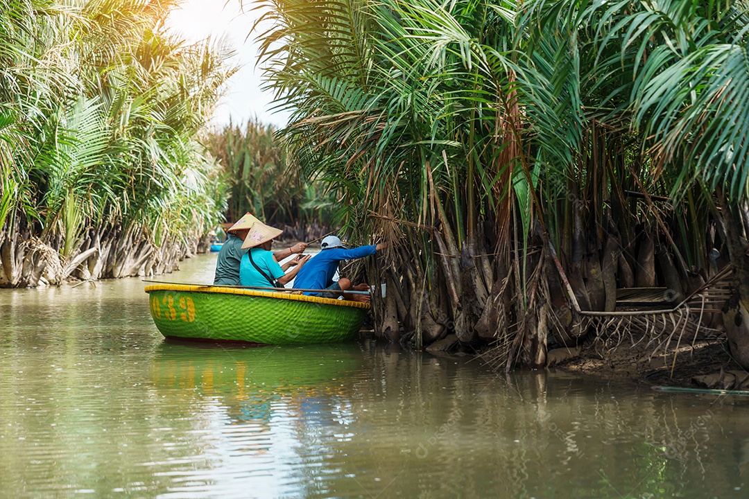 Homem remando um barco de cesta, ao longo da floresta do rio coco
