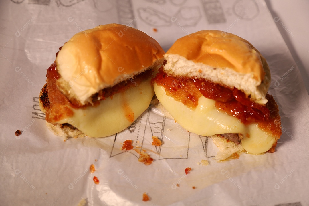 Hamburguer cortado no meio sendo servidos em hamburgueria em fundo branco.