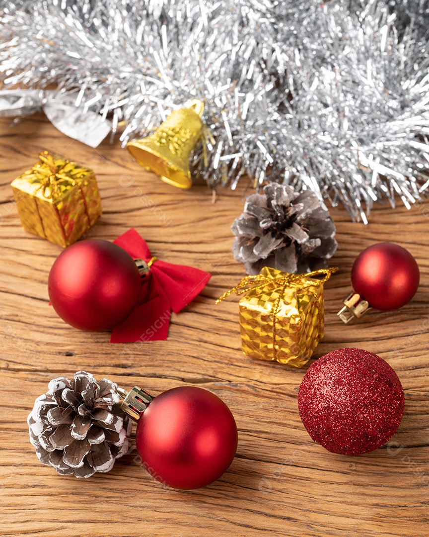 Caixas de presente, pinhas, bolas de natal e arco sobre mesa de madeira