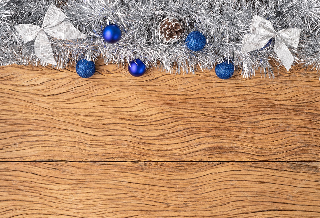 Bolas de natal, pinha e arco sobre mesa de madeira