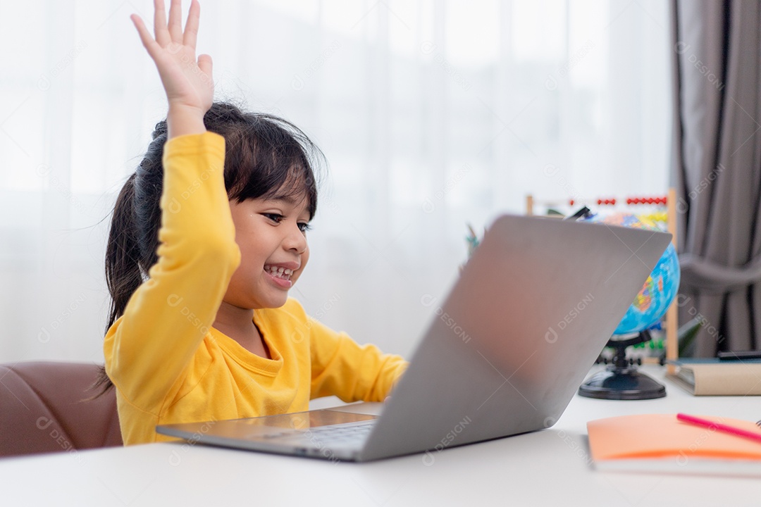 Primeiro dia na escola. Menina asiática que usa um laptop