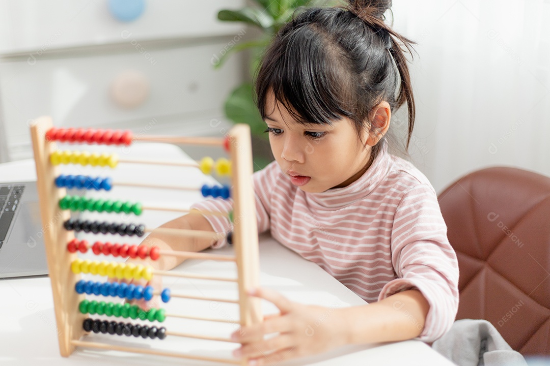Jovem e bonita garota asiática está usando o ábaco com miçangas coloridas