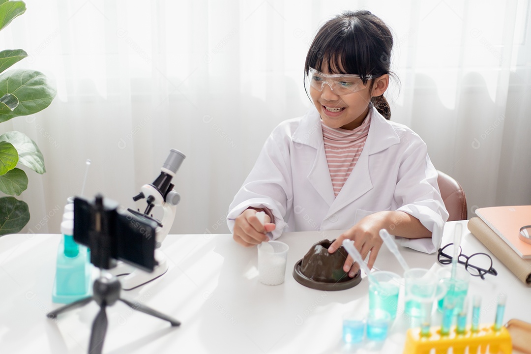 Menina da escola asiática fazendo experimentos de química fáceis e gravando