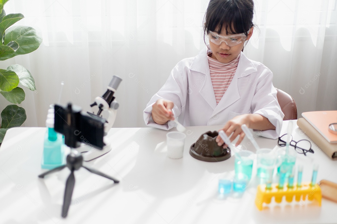 Menina da escola asiática fazendo experimentos de química fáceis e gravando