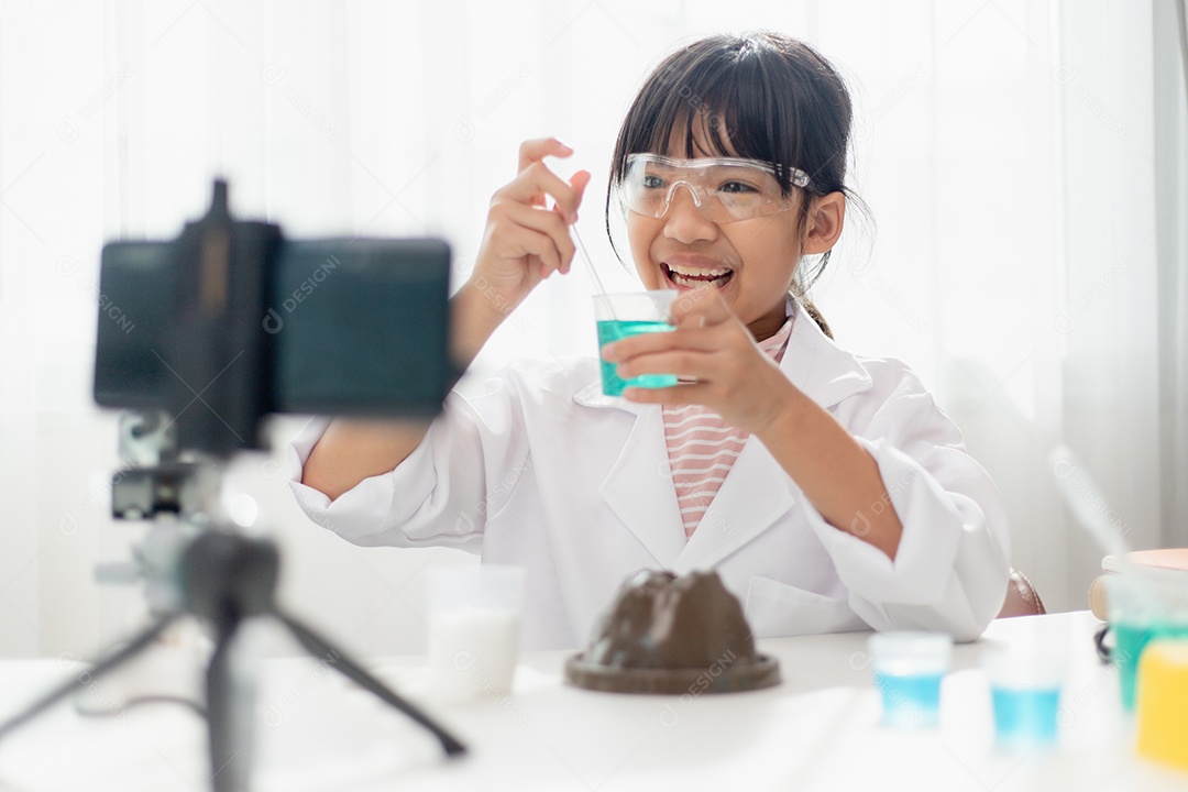 Menina da escola asiática fazendo experimentos de química fáceis e gravando