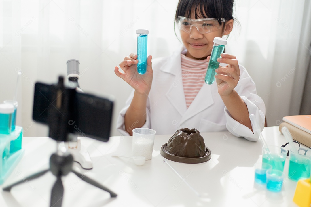 Menina da escola asiática fazendo experimentos de química fáceis e gravando