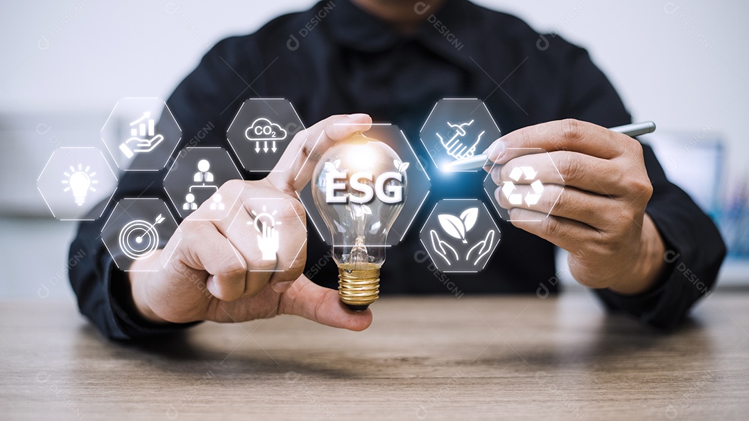 Mão de empresário segurando lâmpada com ícone esg no scr virtual