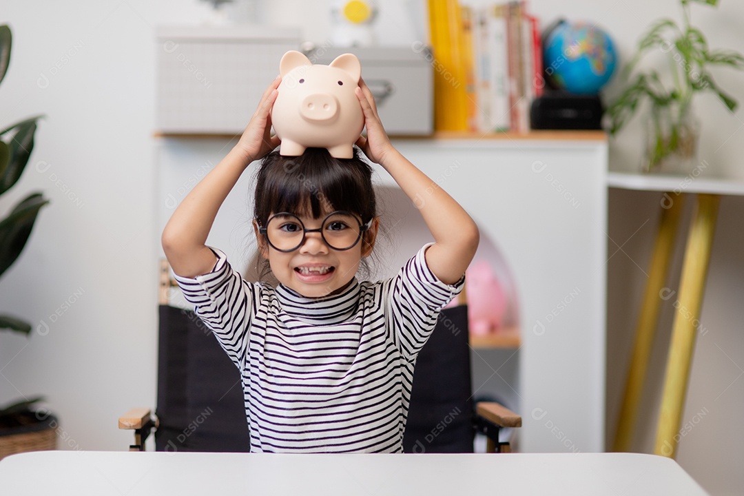 Menina asiática economizando dinheiro em um cofrinho, aprendendo sobre