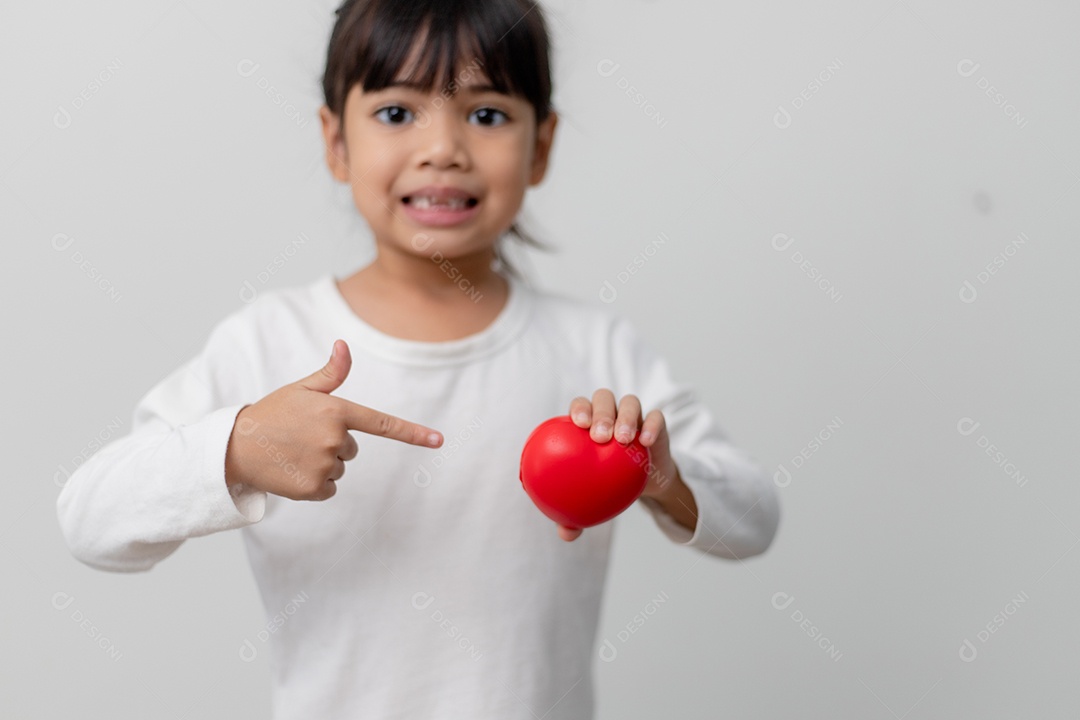 Retrato de uma menina asiática segurando placa de coração vermelho sobre fundo branco