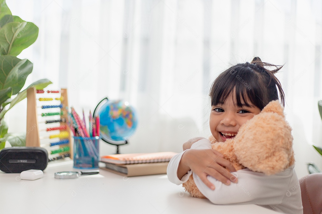 Child playing with teddy bear. Asian girl hugging her favorite.