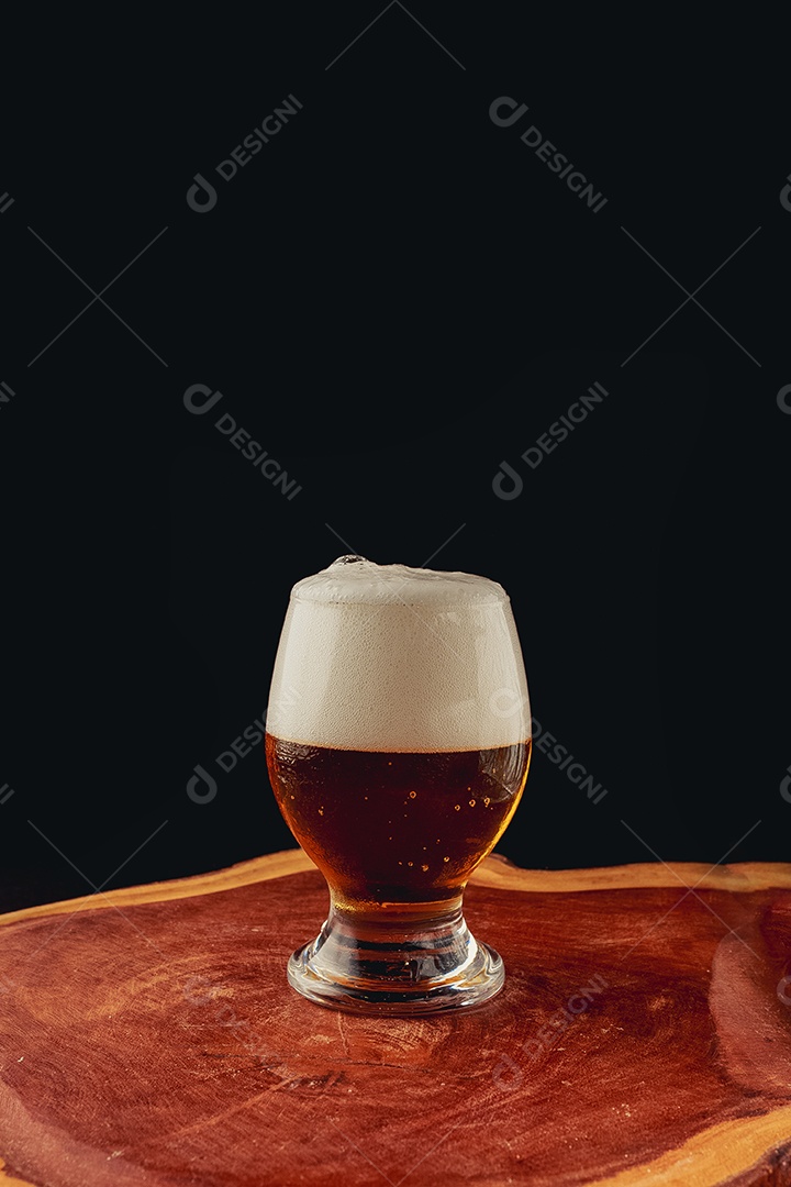 Copo de cerveja sobre uma tabua de madeira