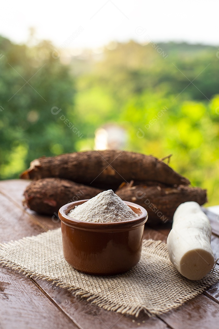Farinha de mandioca com mandioca em segundo plano em uma fazenda