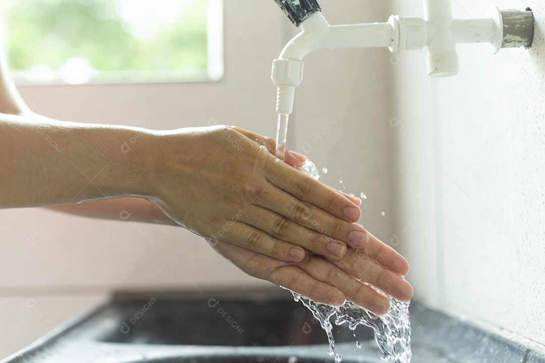 Mãos de pessoa sendo lavada higiene