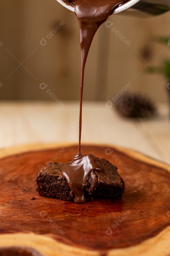 Pedaço de bolo de chocolate calda sobre uma tabua de madeira