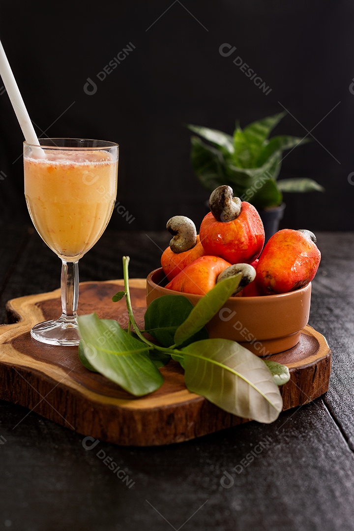 Suco de caju frutas sobre uma tabua de madeira