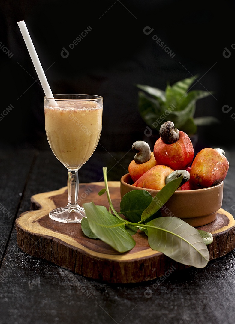 Suco de caju frutas sobre uma tabua de madeira