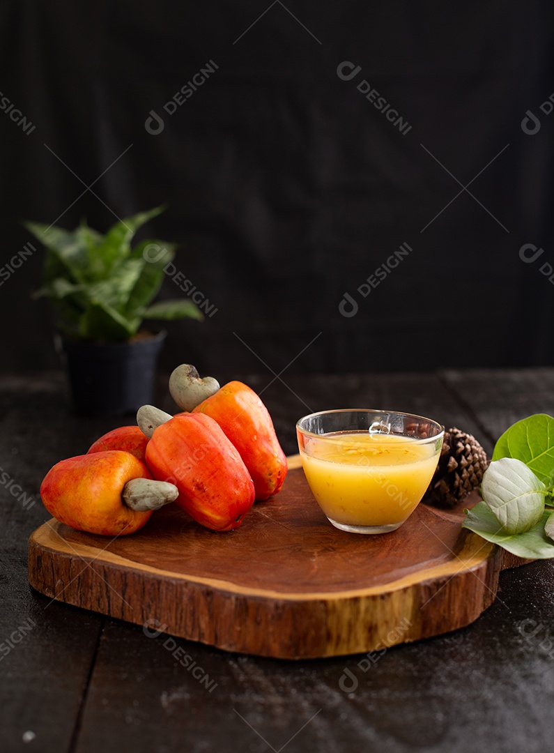 Suco de caju frutas sobre uma tabua de madeira