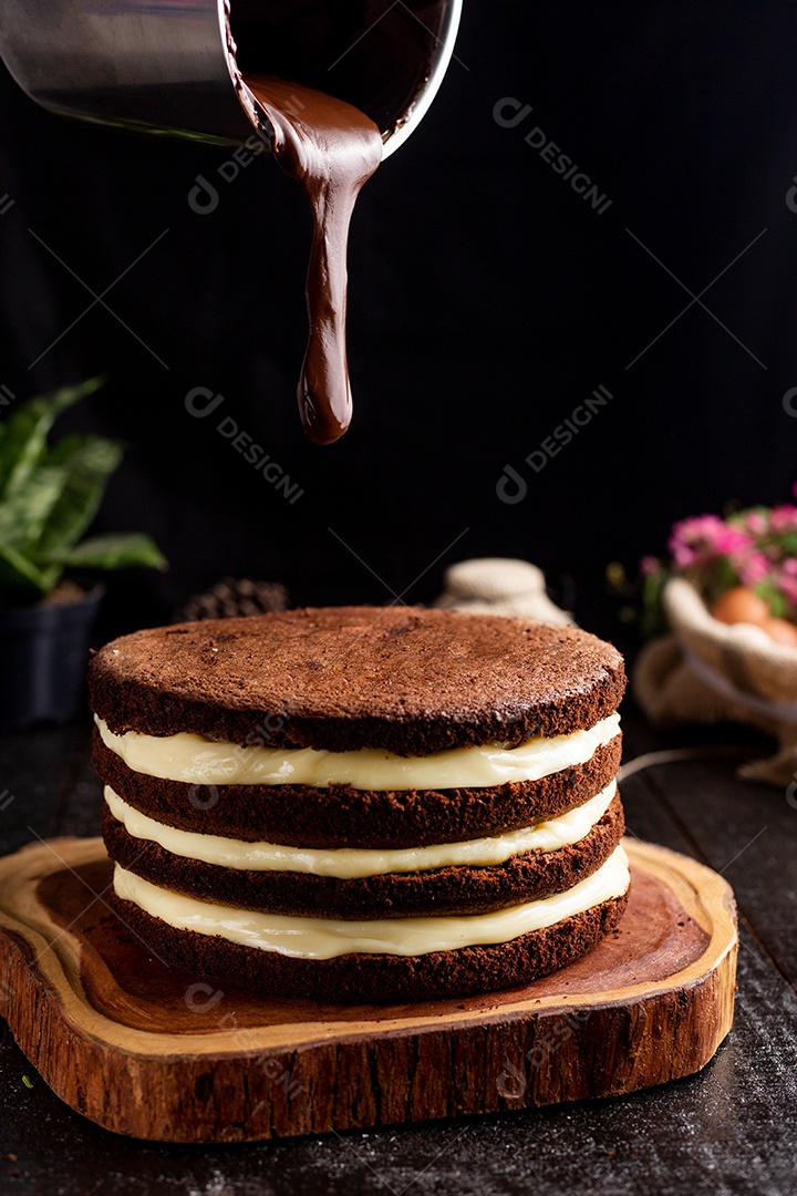 Bolo confeitado de chocolate sobre tabua de madeira