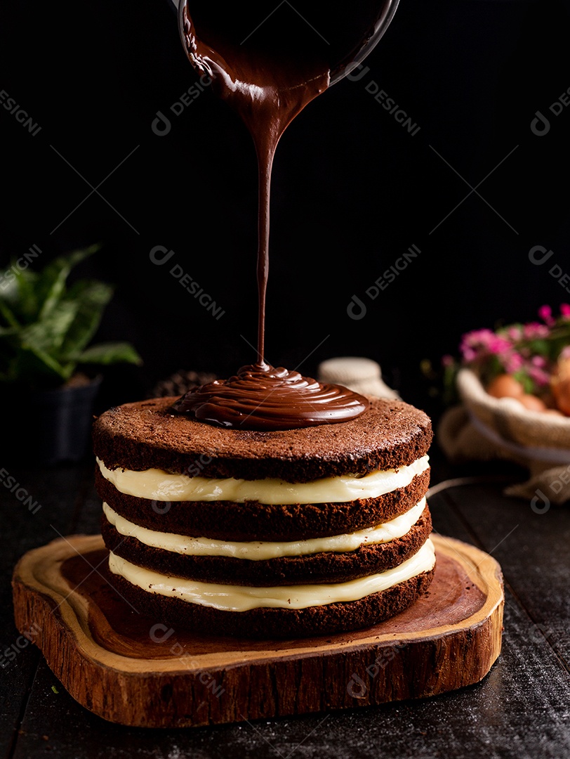 Bolo confeitado de chocolate sobre tabua de madeira