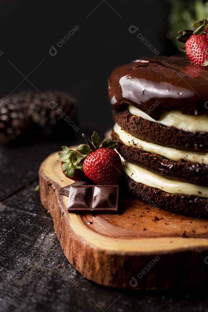 Bolo confeitado de chocolate sobre tabua de madeira