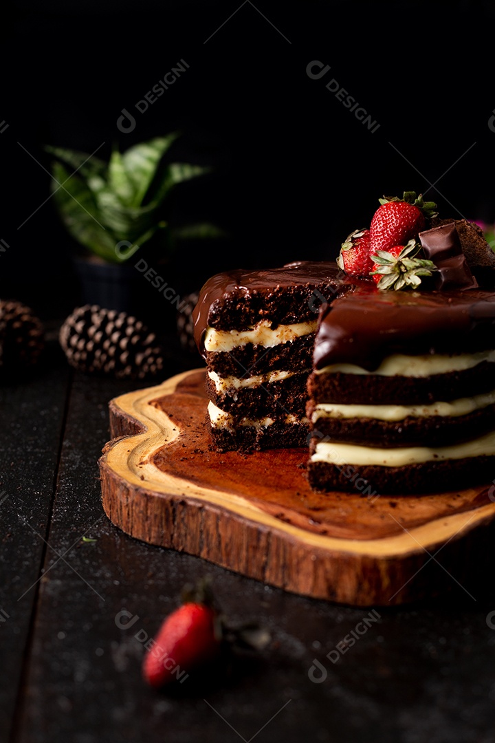 Bolo confeitado de chocolate sobre tabua de madeira