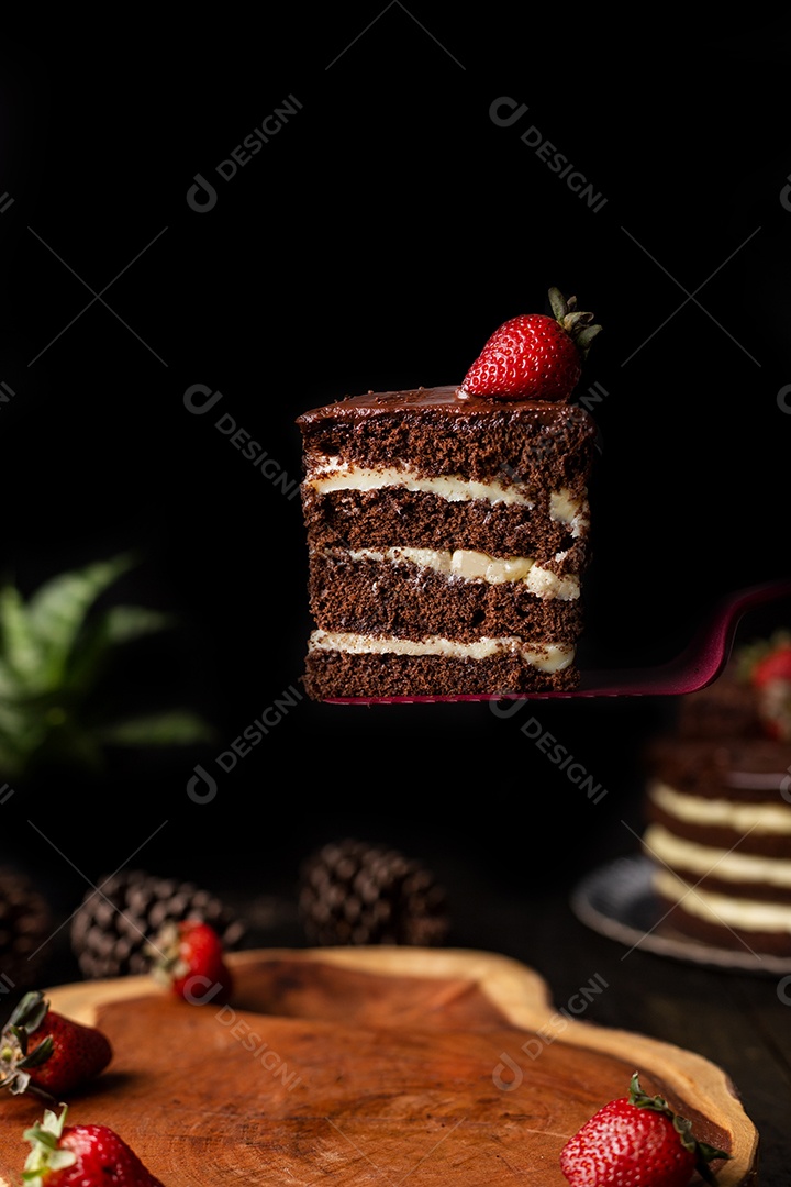 Bolo confeitado de chocolate fatiado sobre tabua de madeira