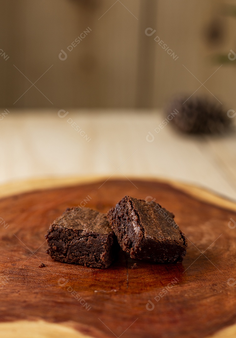 Bolo confeitado de chocolate sobre tabua de madeira