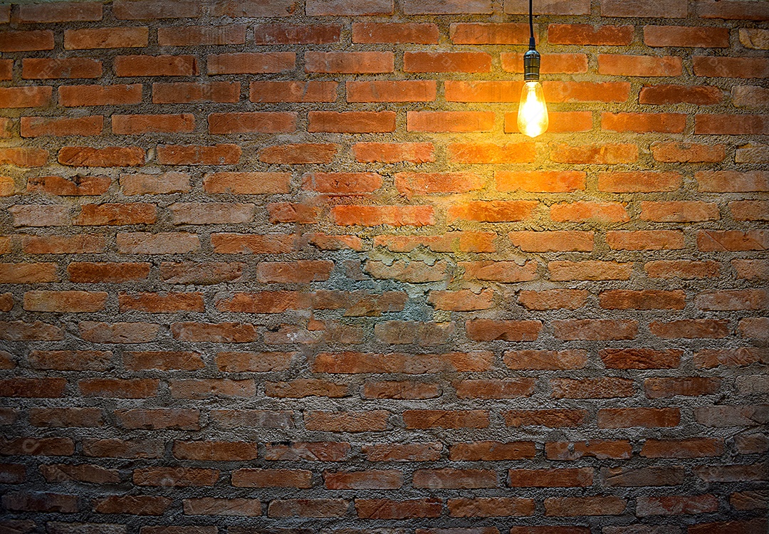 Luz incandescente iluminando uma parede de tijolos.