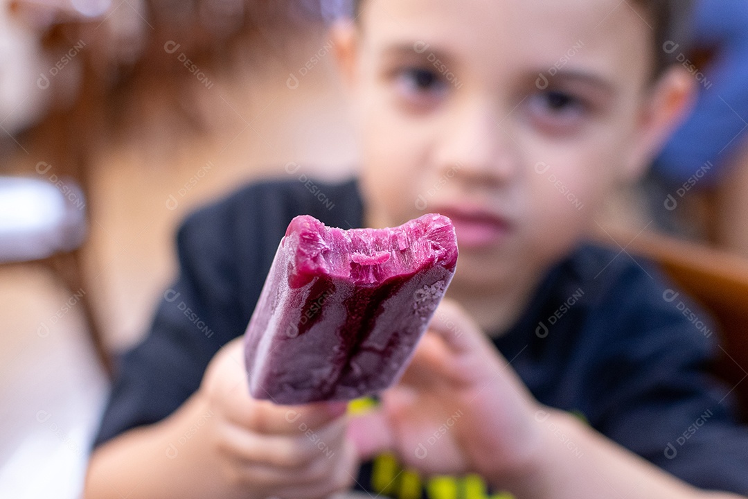 Menino de 5 anos com picolé em padaria brasileira.