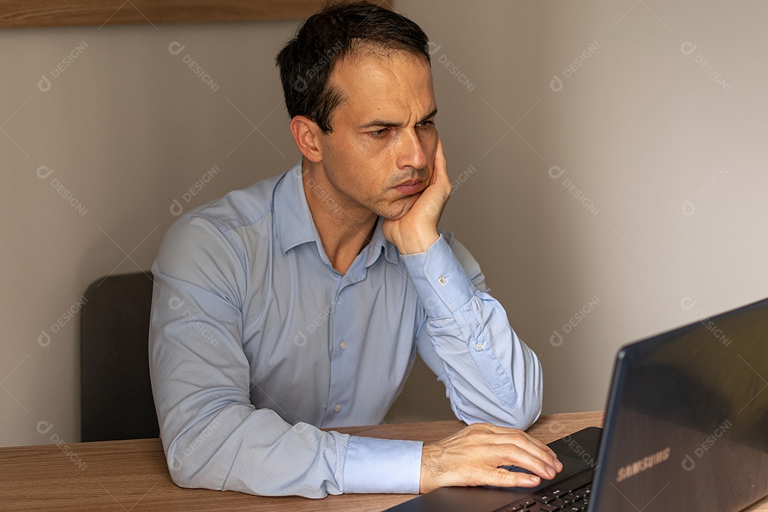 Homem maduro entediado na frente de seu laptop.