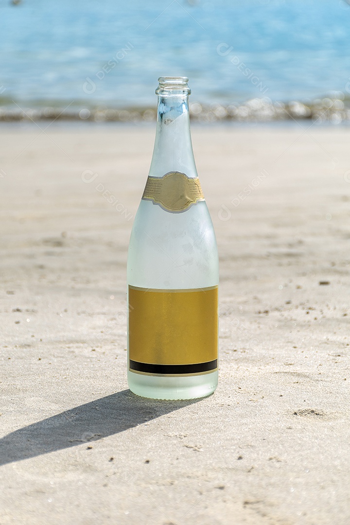 Garrafa de champanhe com a praia ao fundo