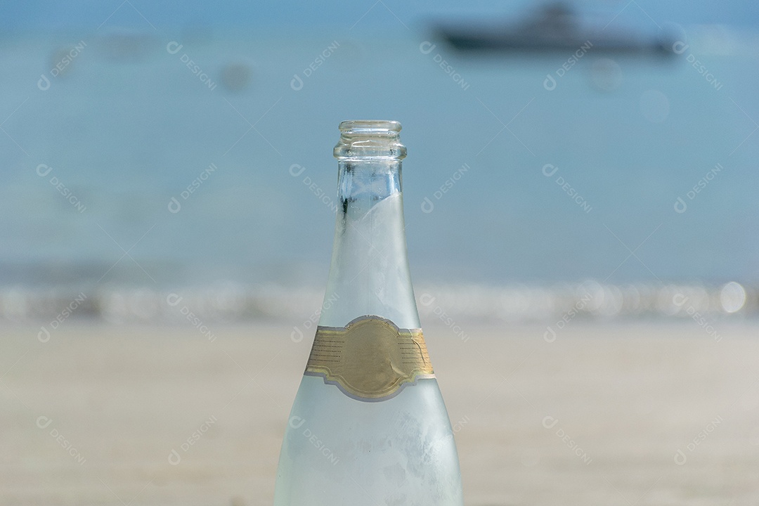 Garrafa de champanhe com a praia ao fundo