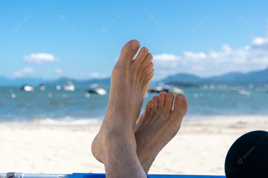 Homem relaxando na praia e ouvindo música.