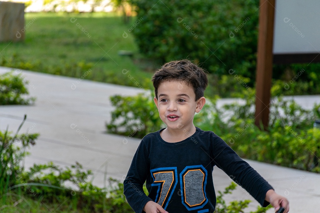 Criança correndo e sorrindo no parque com um pequeno