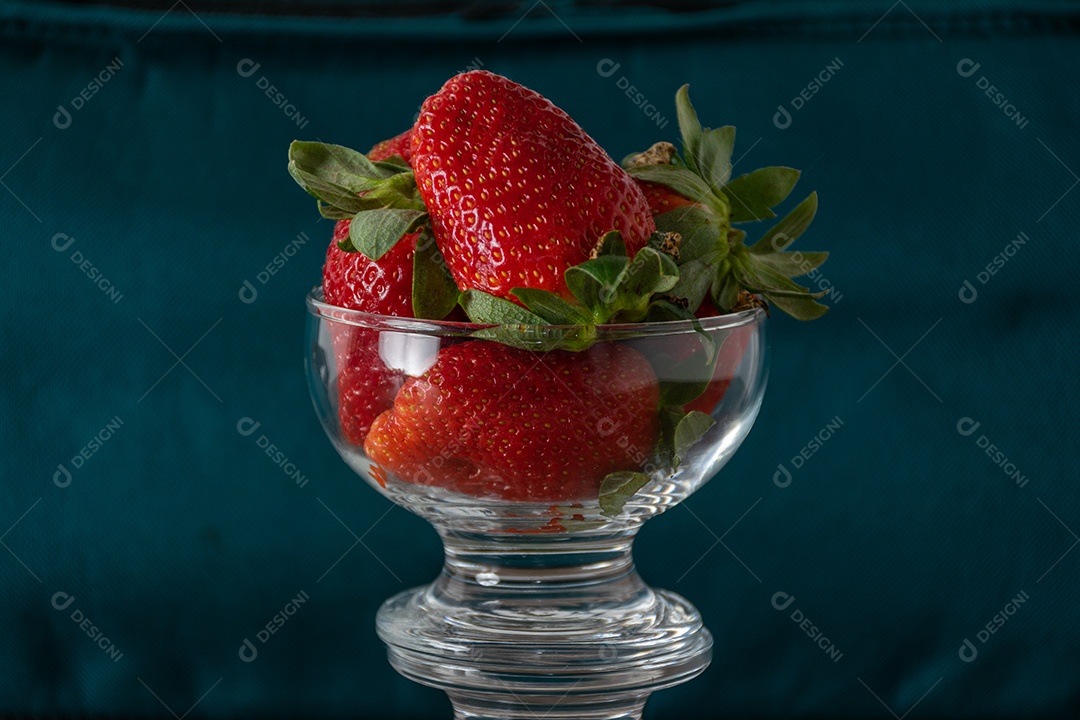 tigela de morangos em fundo azul .