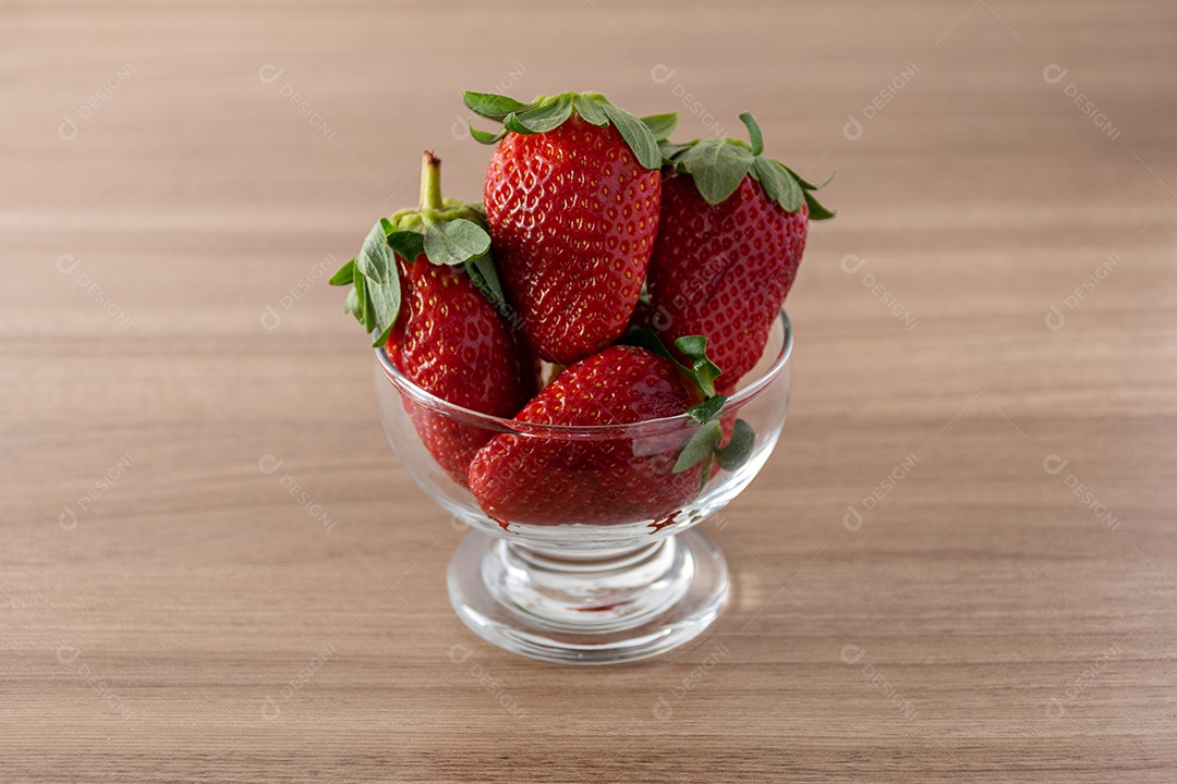 tigela de morangos em fundo de madeira.