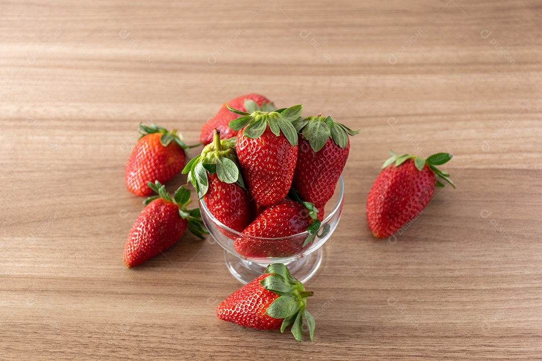 tigela de morangos em fundo de madeira.